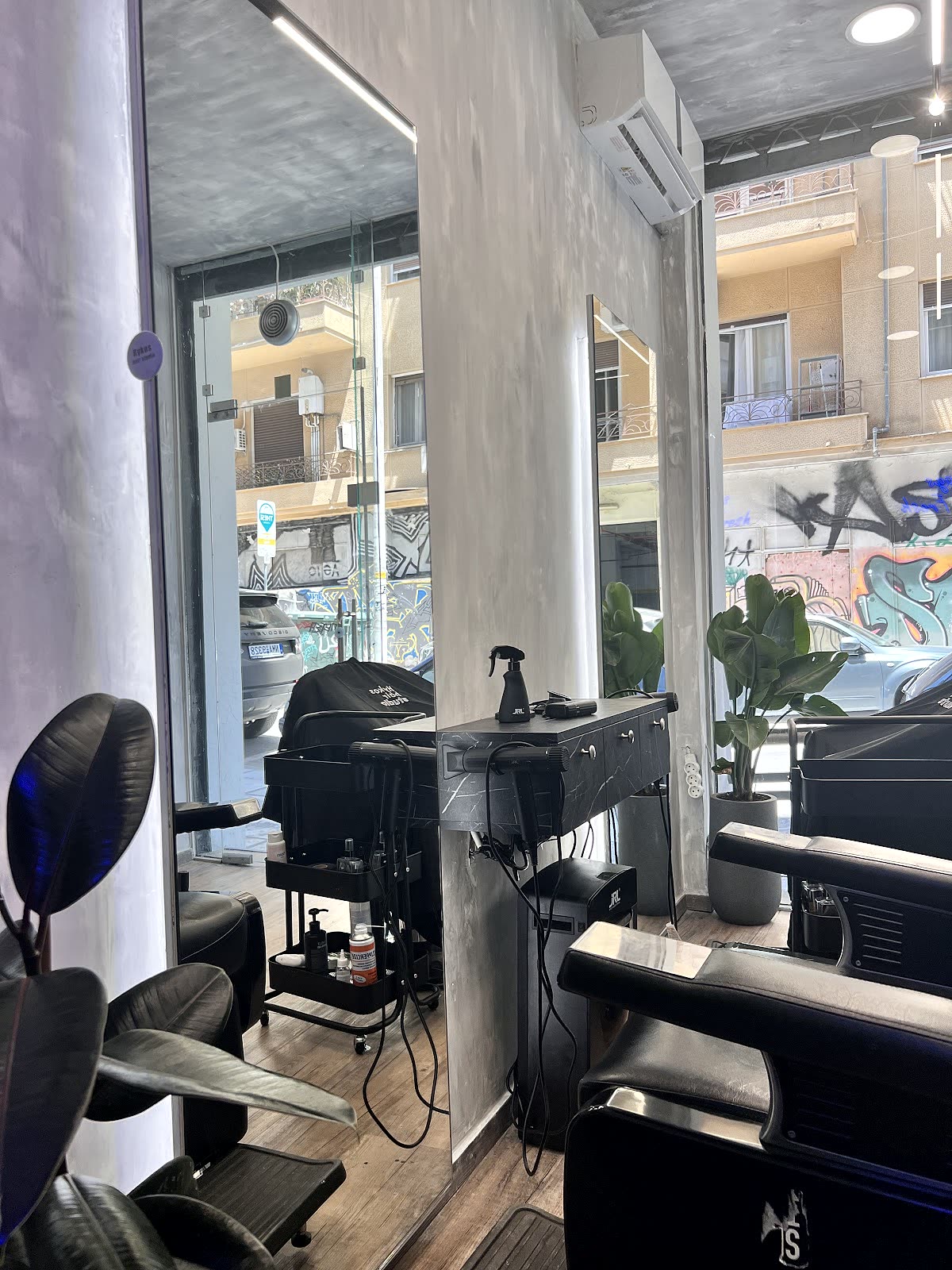 Θέση κουρέματος με καθρέφτη μπροστά στην τζαμαρία, με θέα τον δρόμο